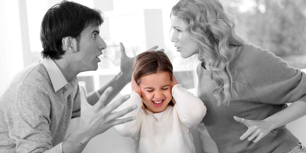 une papa et une maman se disputant et un enfant triste au milieu qui se bouche les oreilles